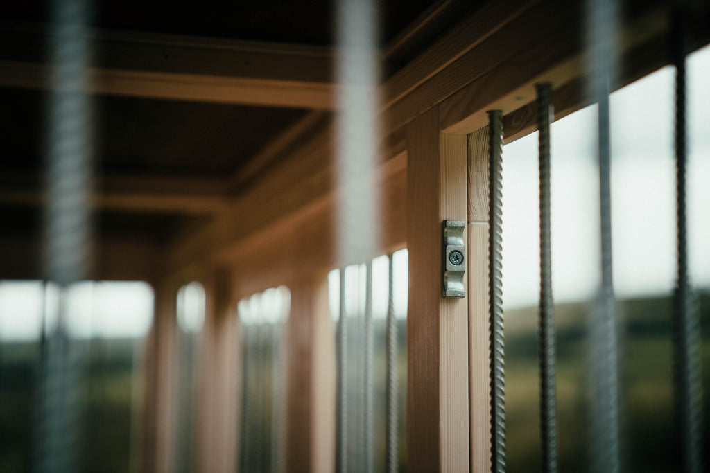 Close-up of secure metal bar fixings inside handcrafted wooden single dog crate, showing strong, safe construction.
