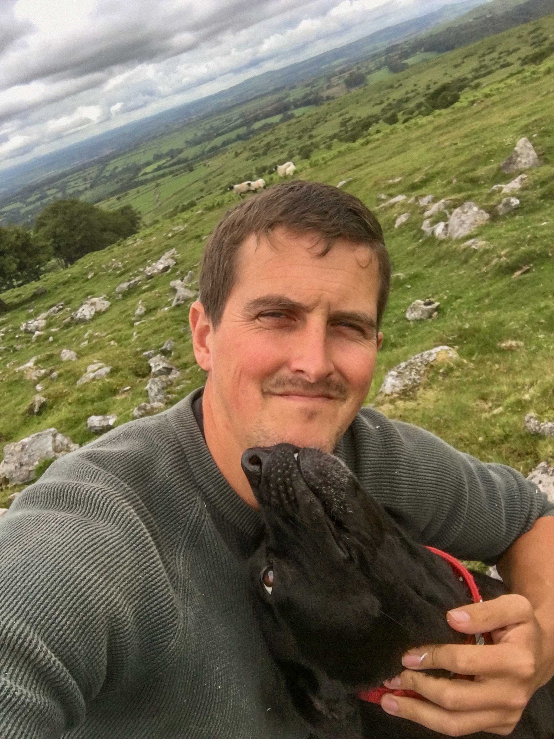 Male Carpenter on Dartmoor countryside with black Labrador, reflecting Countryside Carpentry’s dog-first, handcrafted wooden dog crate ethos