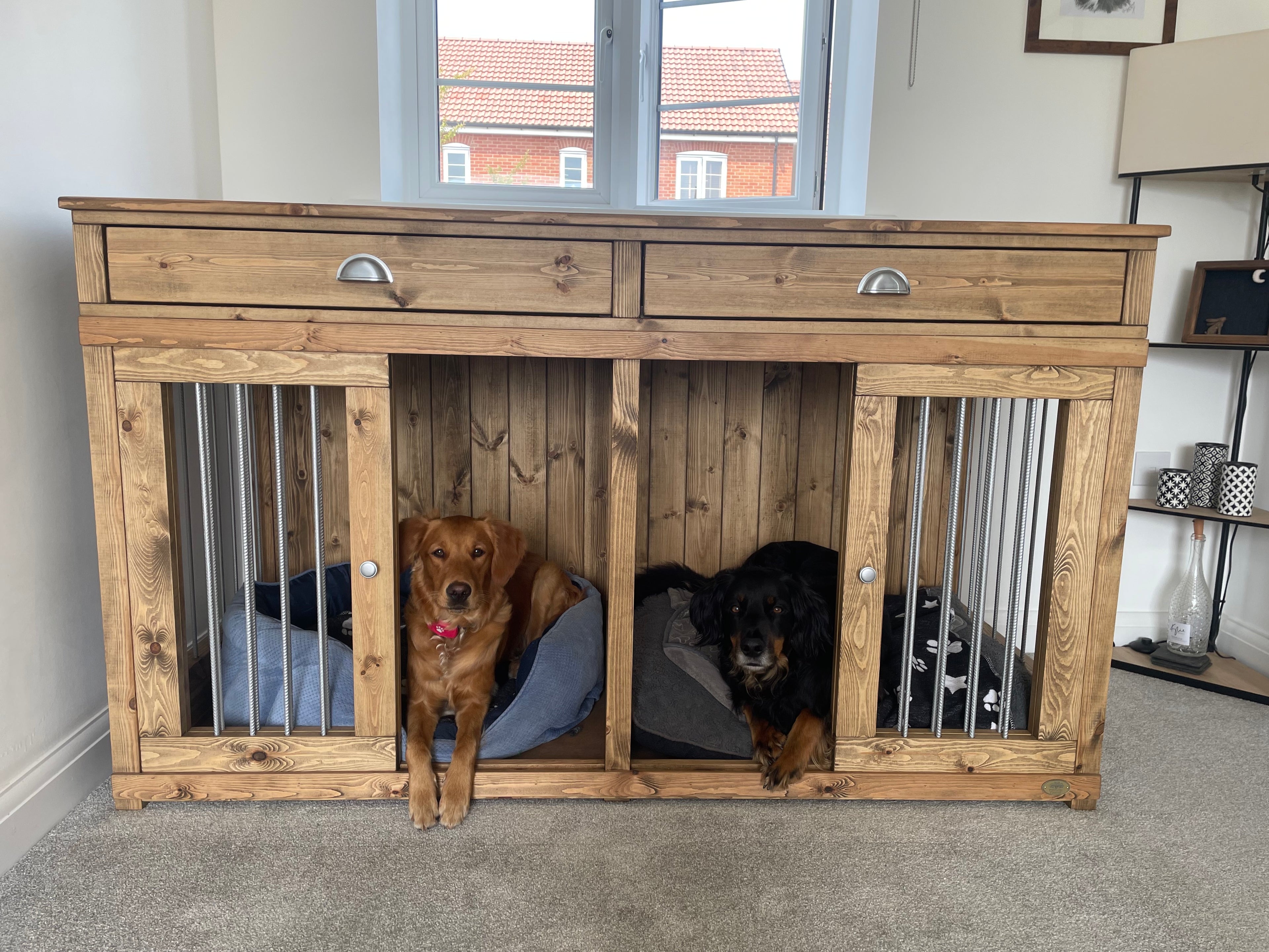 Handcrafted double wooden dog crate with two dogs resting in side-by-side beds, custom indoor wooden dog crate furniture.