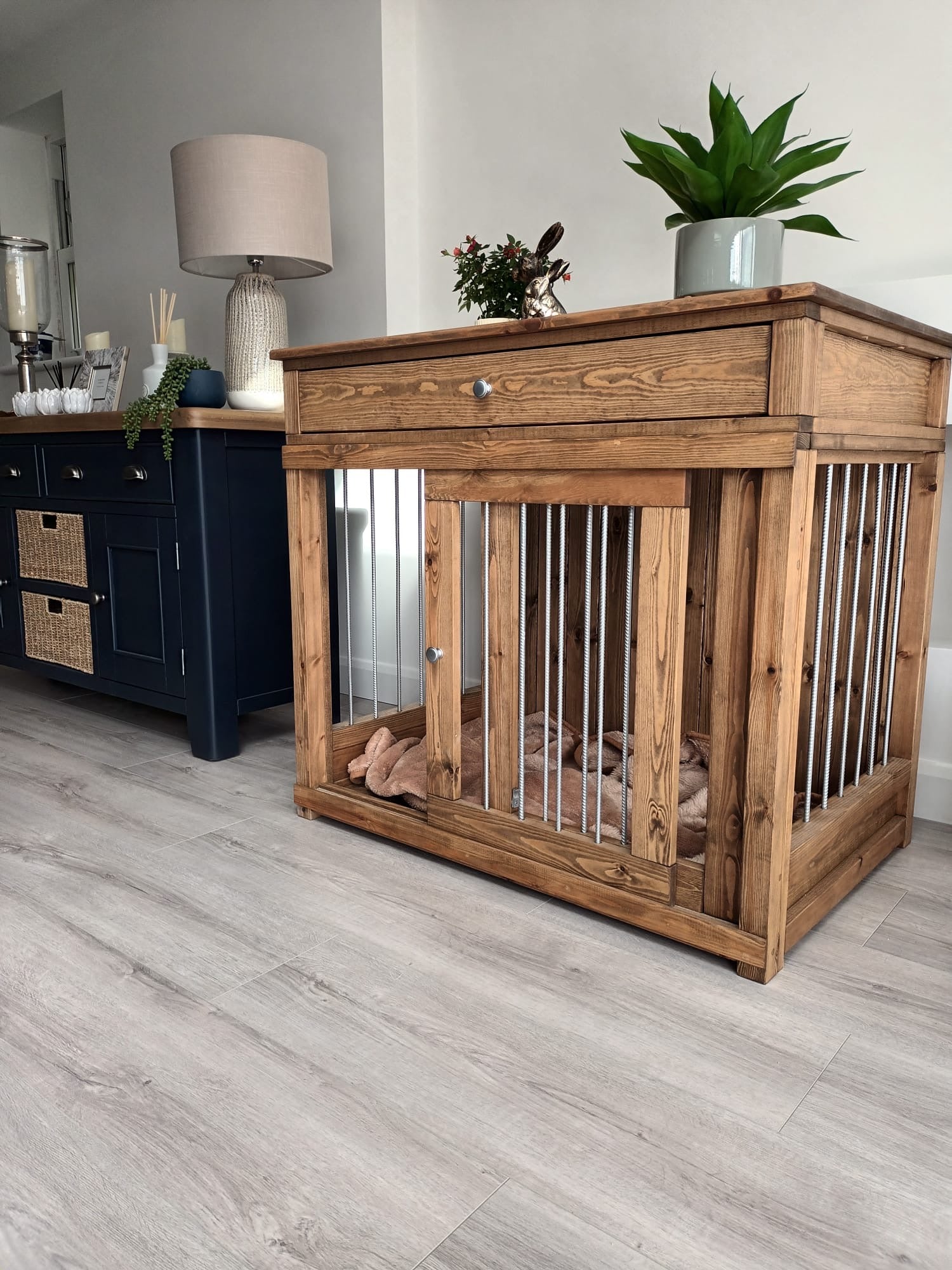 Single wooden dog crate furniture with metal bars and top drawer, styled in a modern hallway interior.